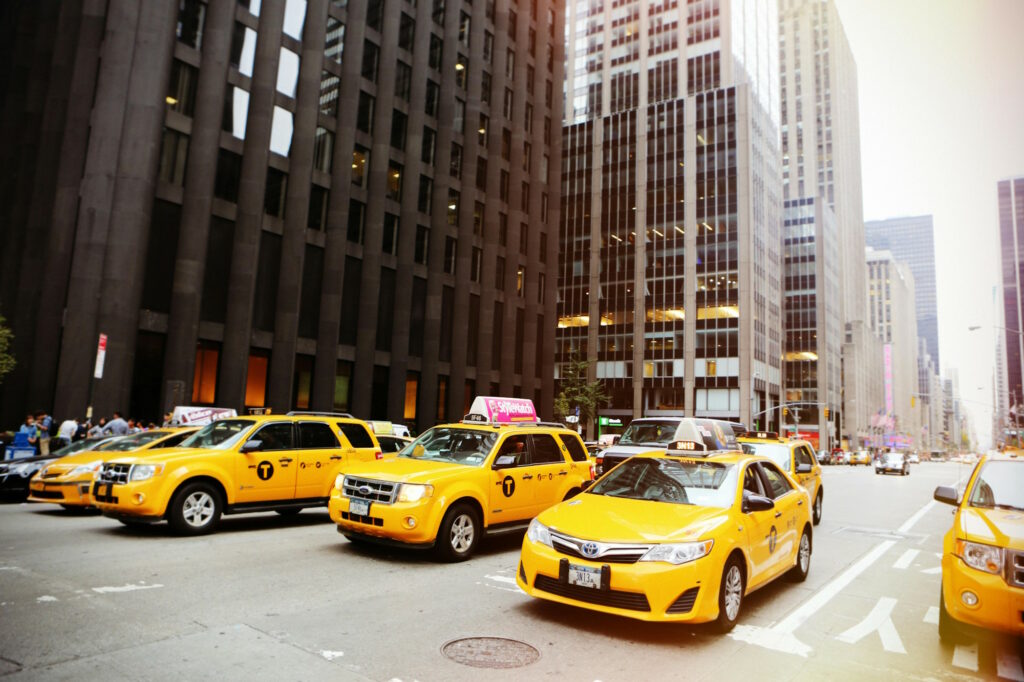 American yellow cabs waiting at the red line inside a modern city with skyscrapers